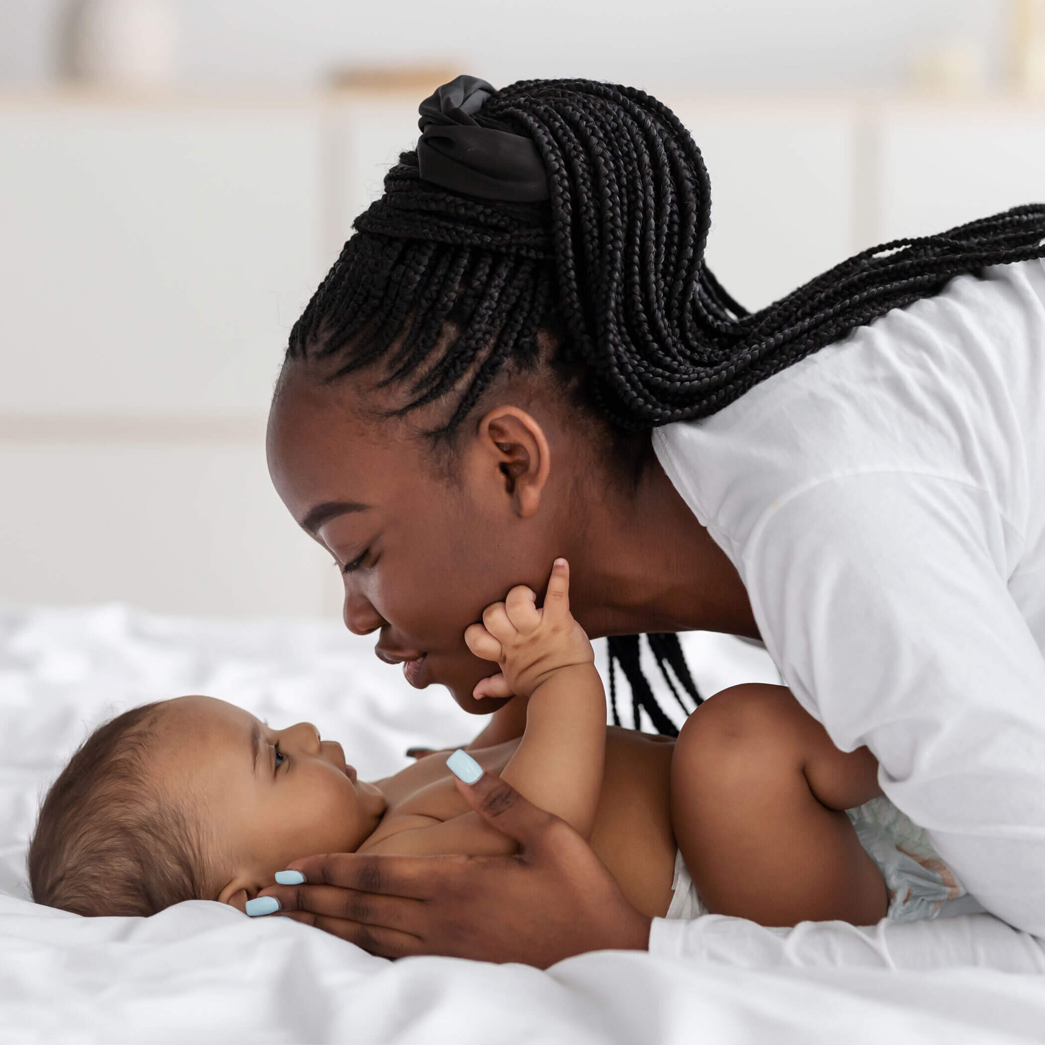 Mother laying her baby down on the bed